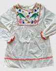 White cotton poplin tunic dress for girls with colorful embroidered sea life details, including turtles, fish, and coral, with a button-front closure and short sleeves.